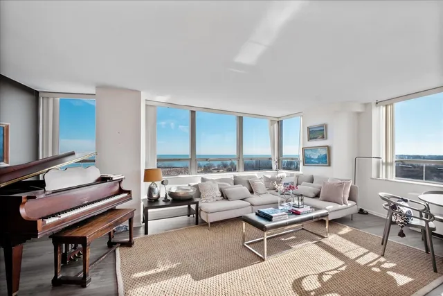 a living room with furniture a table and a large window