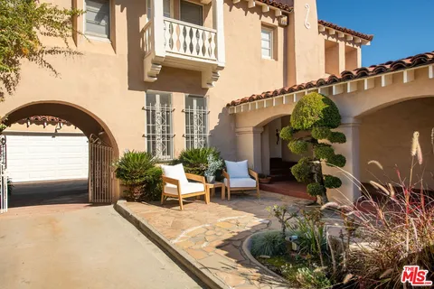 a view of a pathway of a house with potted plants