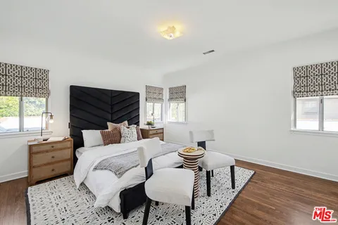 a living room with a table chairs and a wooden floor