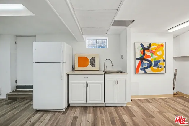 a view of a yard with plants and a large tree