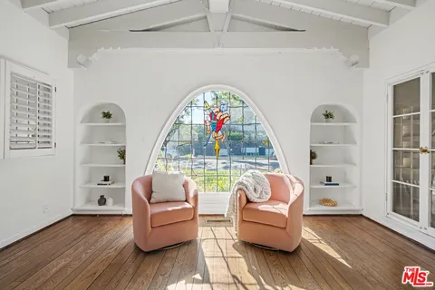 a dining room with furniture a chandelier and wooden floor