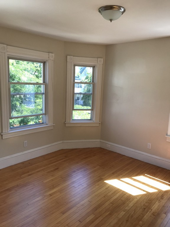 65 Grand Street Springfield, MA 01108 - Photo 19 of 30 a view of an empty room with wooden floor and a window