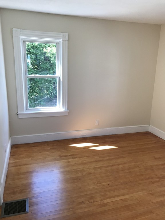 65 Grand Street Springfield, MA 01108 - Photo 21 of 30 a view of an empty room with wooden floor and a window
