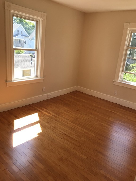 65 Grand Street Springfield, MA 01108 - Photo 22 of 30 an empty room with wooden floor and windows