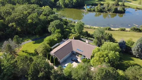 an aerial view of house with yard and lake view