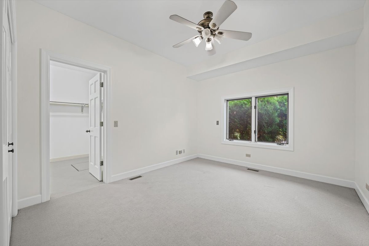 7510 East Tryon Grove Road Richmond, IL 60071 - Photo 34 of 63 an empty room with a ceiling fan and a window