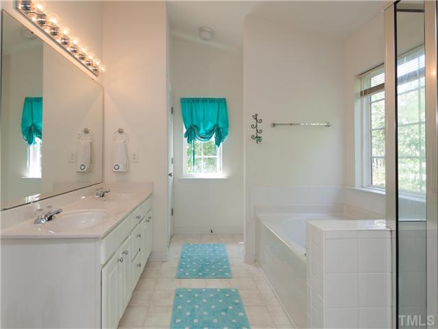 8433 Aztec Dawn Court Raleigh, NC 27613 - Photo 15 of 23 Luxurious Master Bath features dual cultured marble sinks/counters, bright white vanity cabinet, separate shower and a garden tub with window above and another window at the far end of the bathroom for added natural light!