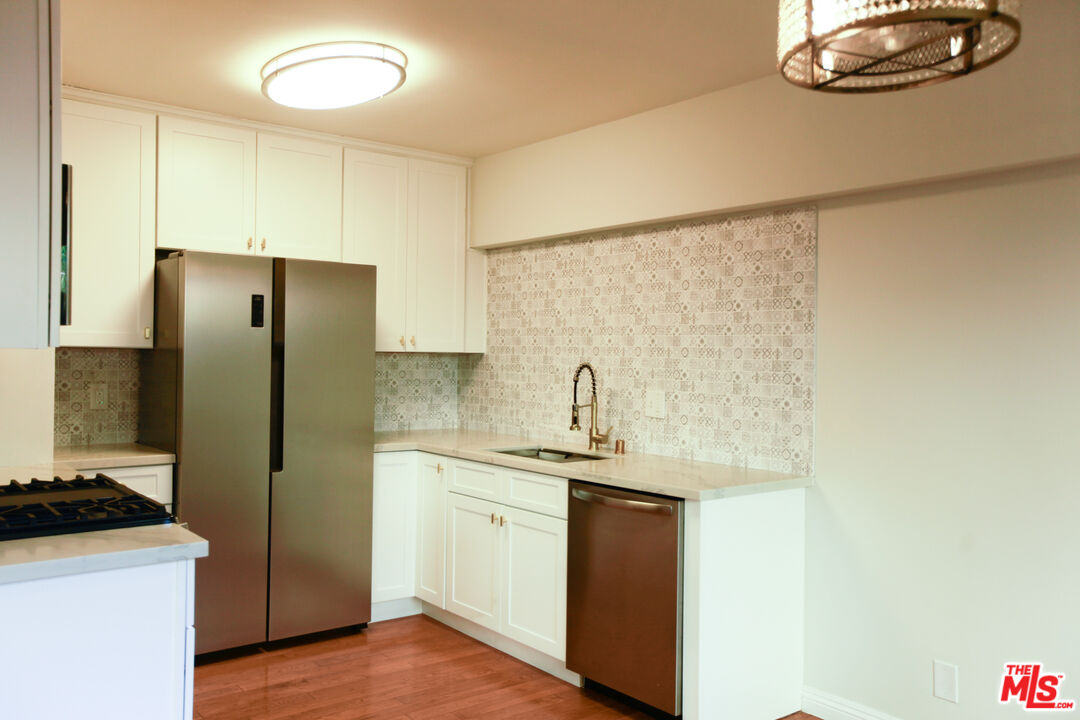 1323 South Ridgeley Drive, Unit 2 Los Angeles, CA 90019 - Photo 2 of 11 a kitchen with stainless steel appliances granite countertop a refrigerator and a sink