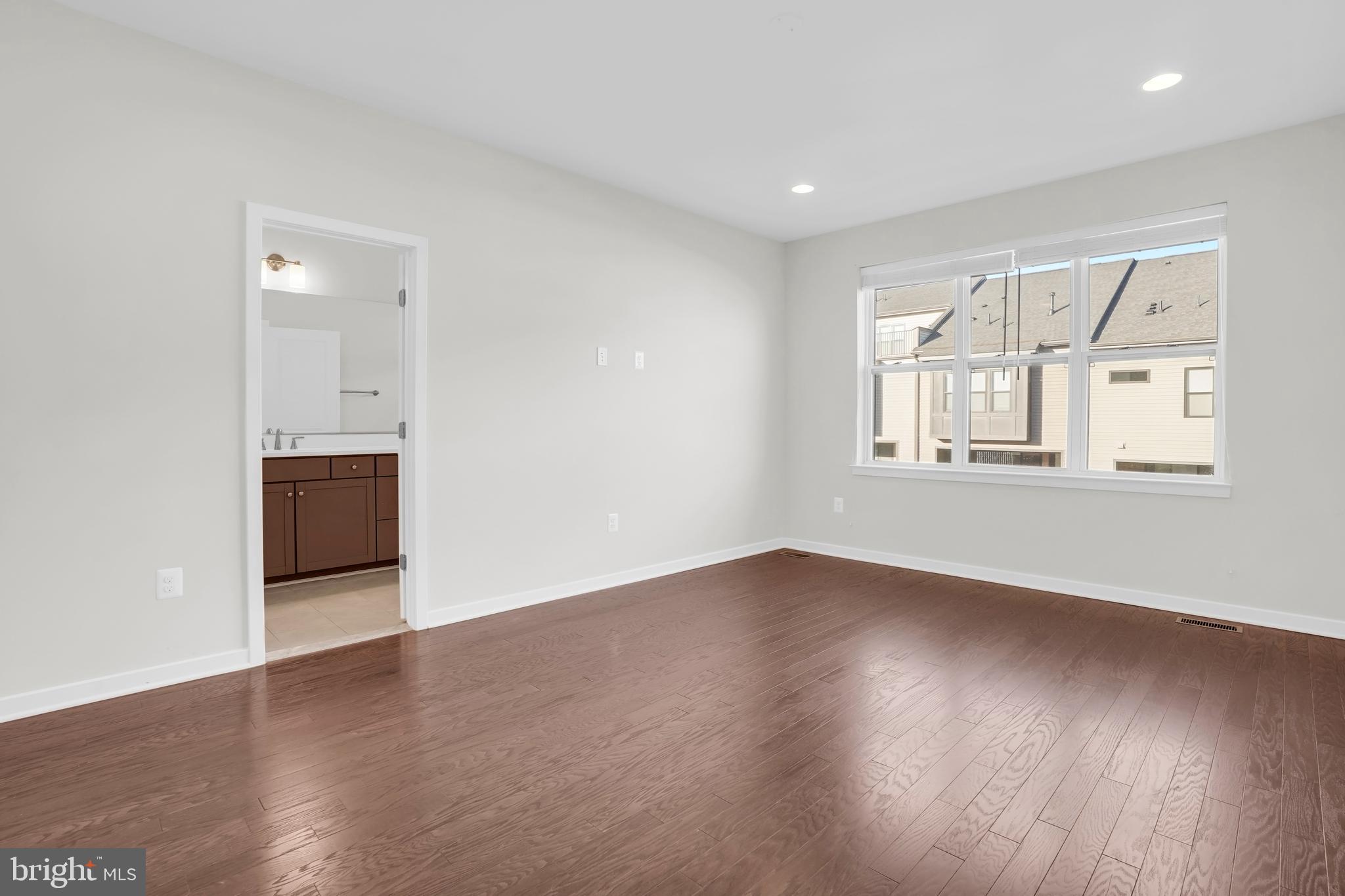 22954 Sullivans Cove Square Brambleton, VA 20148 - Photo 19 of 38 an empty room with wooden floor and windows