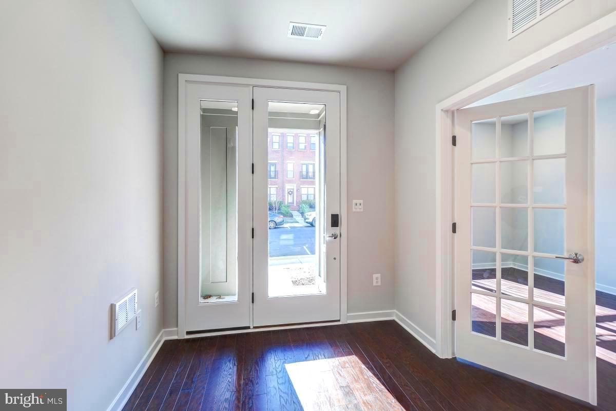 22954 Sullivans Cove Square Brambleton, VA 20148 - Photo 3 of 38 an empty room with wooden floor and windows