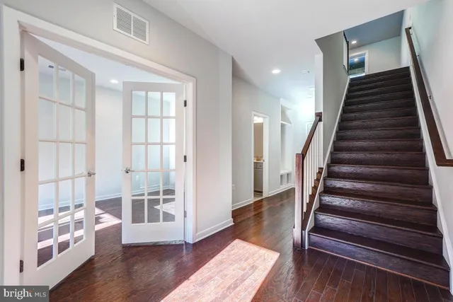 a view of a hallway with wooden floor and windows