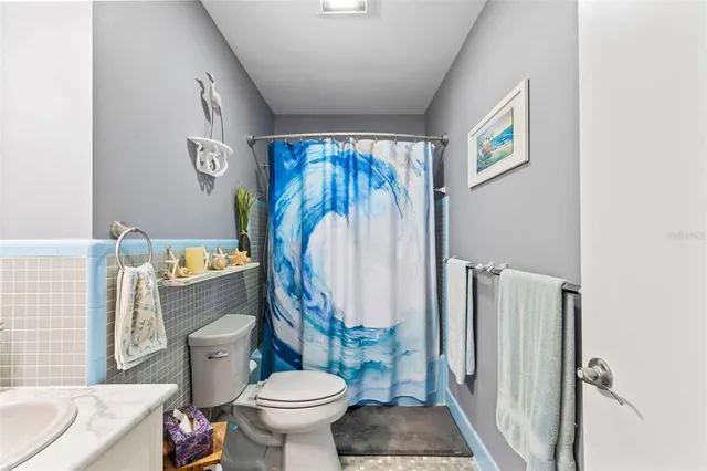 a bedroom with a bed a dresser and wooden floor