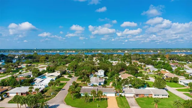 an aerial view of residential houses with outdoor space and trees