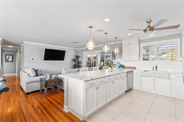 a large white kitchen with a stove a sink dishwasher and a microwave oven with white cabinets