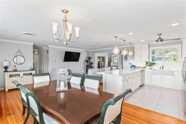 a kitchen with stainless steel appliances granite countertop a stove top oven a dining table and chairs with wooden floor