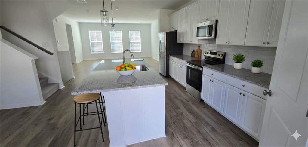 93 Wilder Ridge Way Lawrenceville, GA 30044 - Photo 3 of 8 a kitchen with stainless steel appliances a white wooden cabinets a stove a sink and a window
