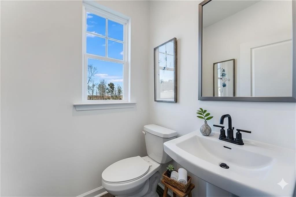 93 Wilder Ridge Way Lawrenceville, GA 30044 - Photo 7 of 8 a bathroom with a toilet a sink and mirror