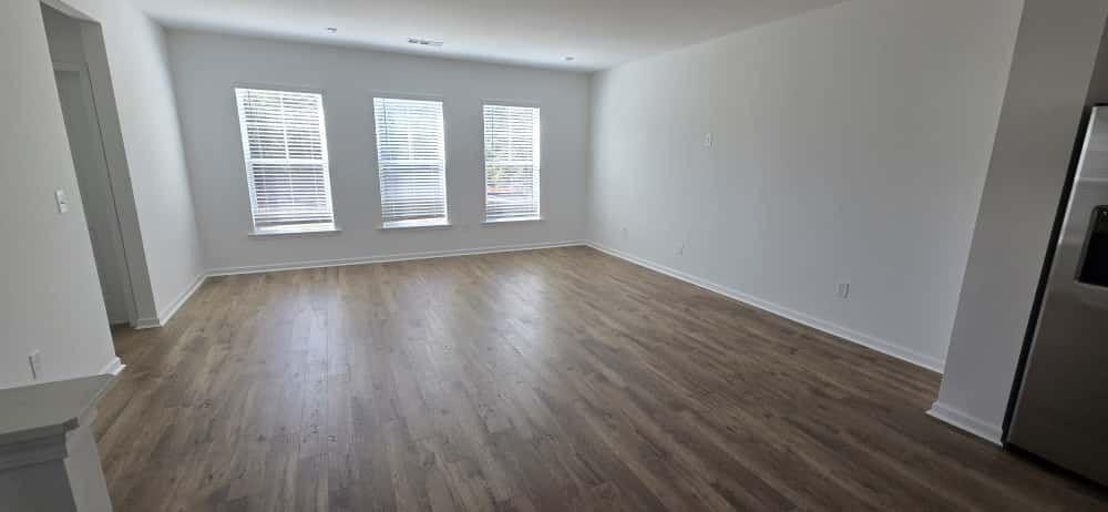 93 Wilder Ridge Way Lawrenceville, GA 30044 - Photo 8 of 8 an empty room with wooden floor and windows