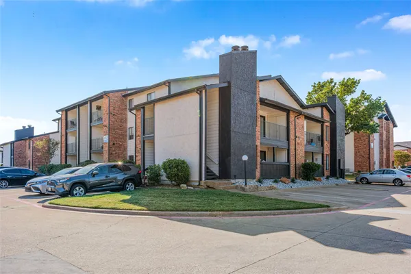 a front view of multi story residential apartment building with yard and outdoor seating