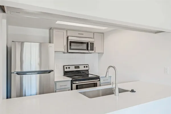 a kitchen with a refrigerator and a stove top oven