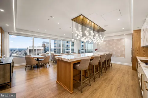 a kitchen with stainless steel appliances granite countertop a stove and a living room with furniture