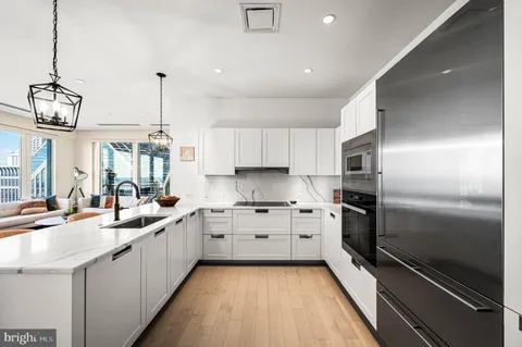 a kitchen with stainless steel appliances granite countertop a sink and a refrigerator