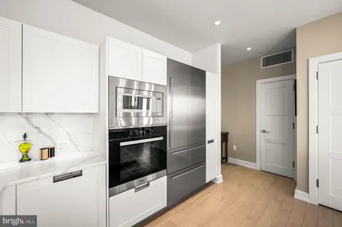 a kitchen with stainless steel appliances granite countertop a refrigerator and a stove top oven