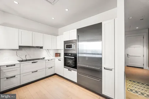 a kitchen with white cabinets and refrigerator