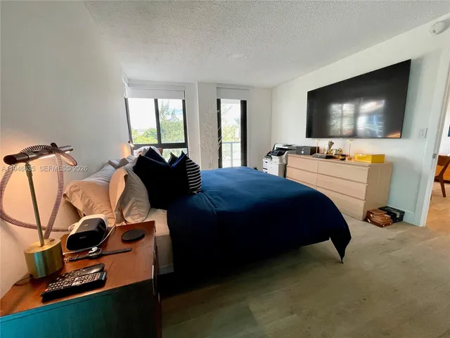 a bedroom with a bed and a flat screen tv