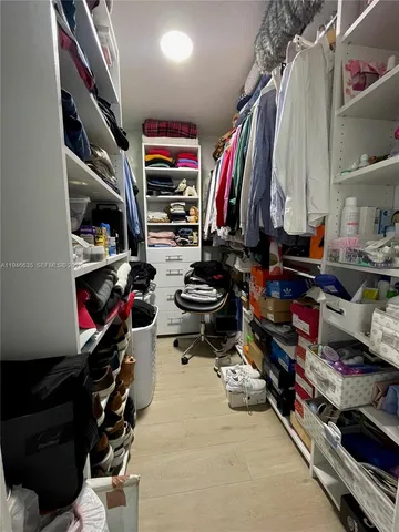 a view of walk in closet with clothes and shoes
