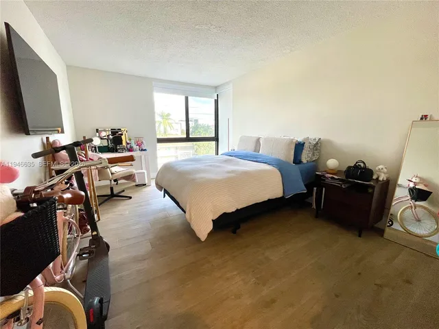 a bedroom with a bed and a flat tv screen on the dresser