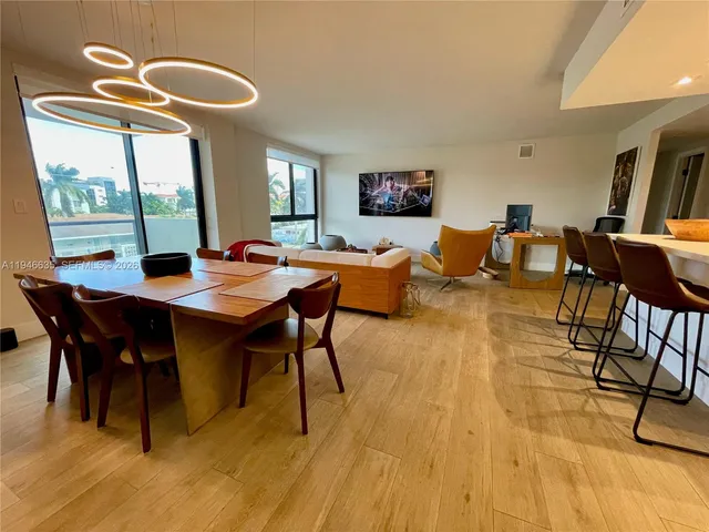 a dining room with furniture a rug and a floor to ceiling window