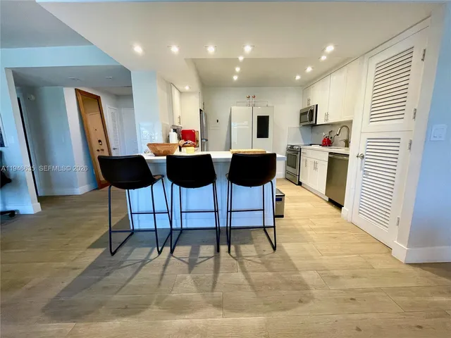 a living room with furniture a rug and kitchen view