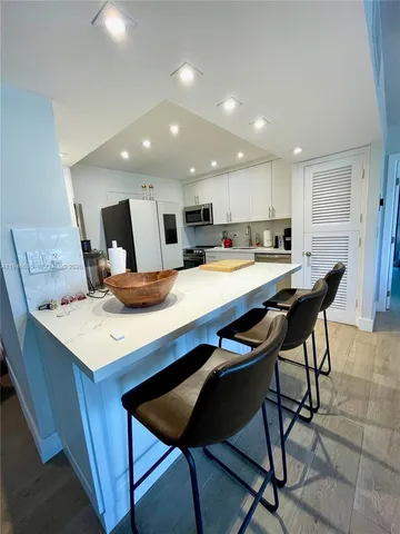 a kitchen with a dining table chairs and refrigerator
