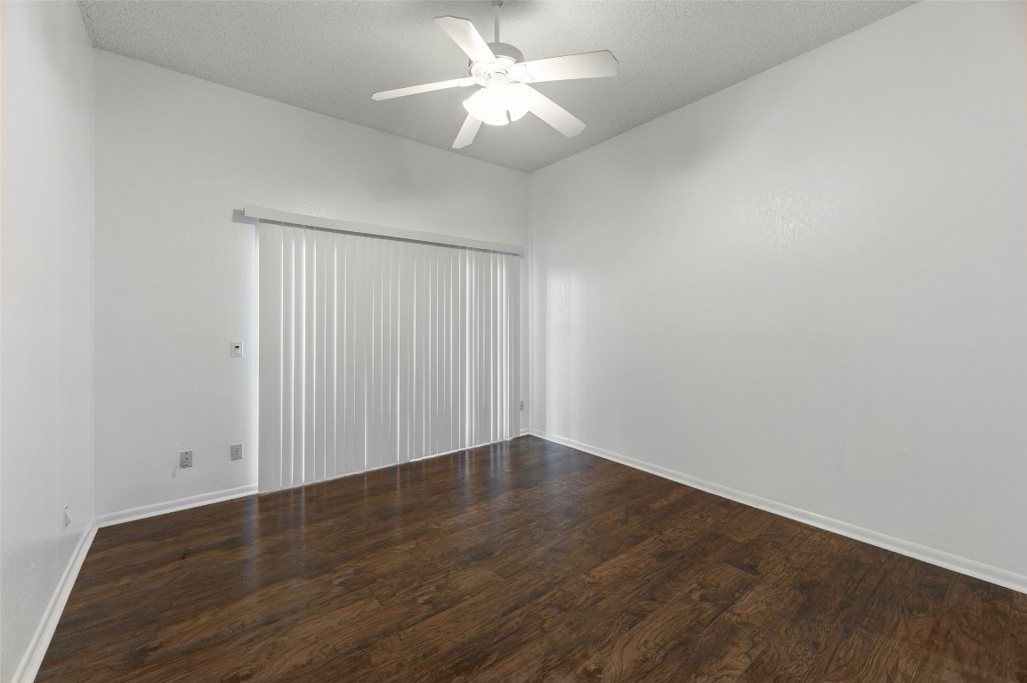 409 Hi There, Unit M Horseshoe Bay, TX 78657 - Photo 16 of 33 Spare room featuring a ceiling fan, dark wood-type flooring, and a textured ceiling