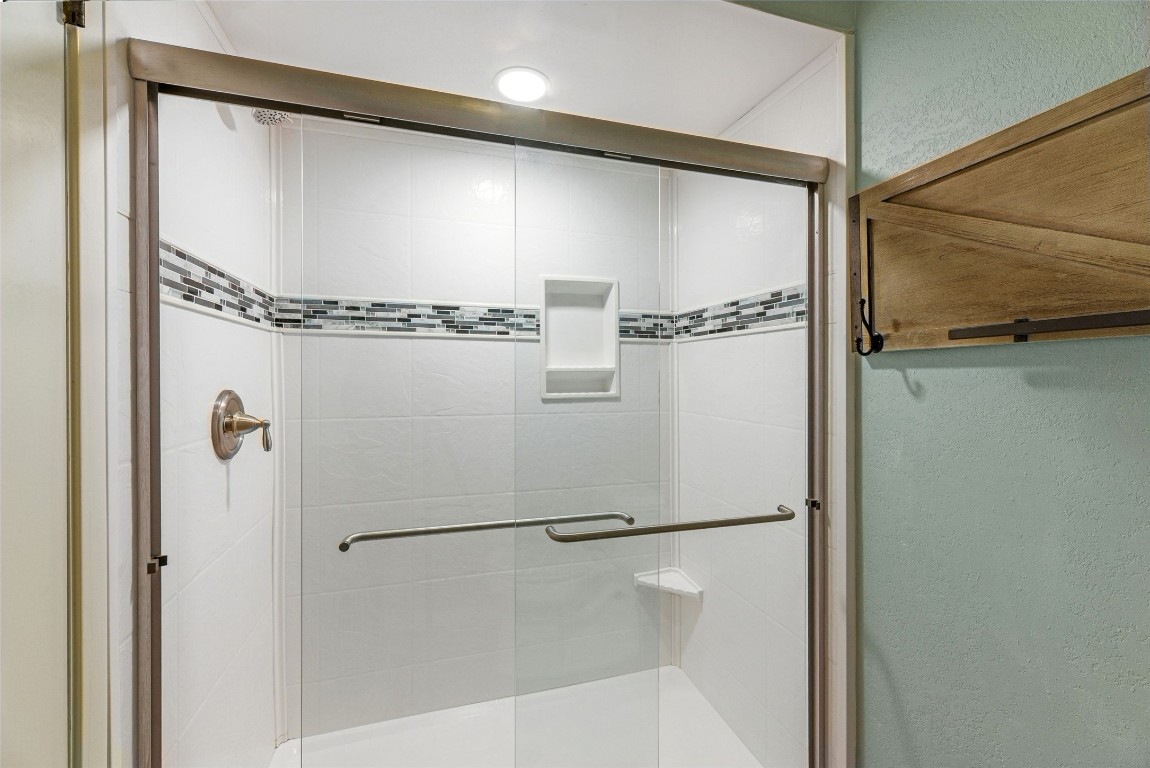 409 Hi There, Unit M Horseshoe Bay, TX 78657 - Photo 19 of 33 Bathroom featuring a shower stall and a textured wall