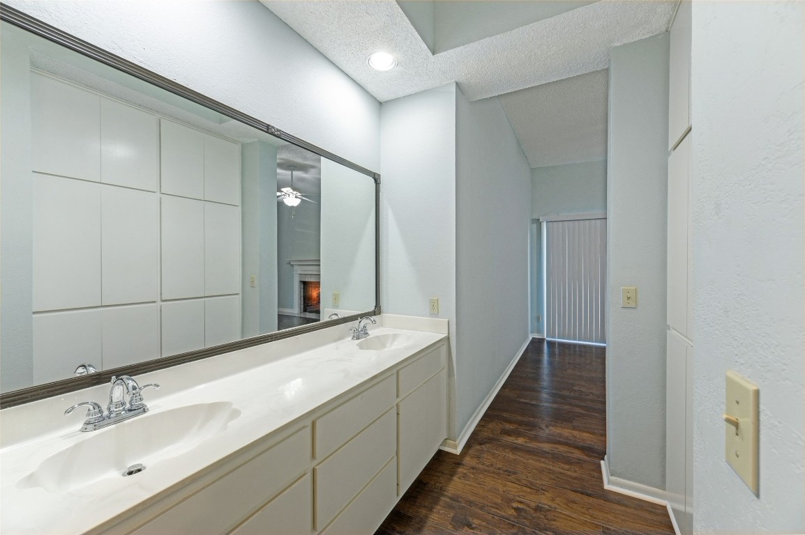 409 Hi There, Unit M Horseshoe Bay, TX 78657 - Photo 21 of 33 Bathroom with double vanity, dark wood-style flooring, a lit fireplace, a ceiling fan, and recessed lighting