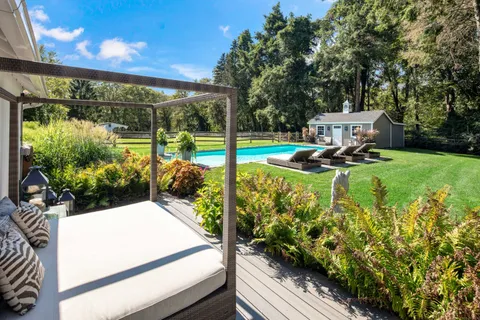 a view of a house with a wooden bench in the patio