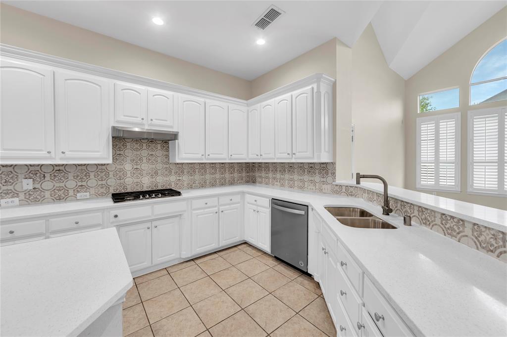 3920 Autumn Lane Bedford, TX 76021 - Photo 11 of 36 Kitchen featuring white cabinetry, light-colored countertops, and a patterned tile backsplash