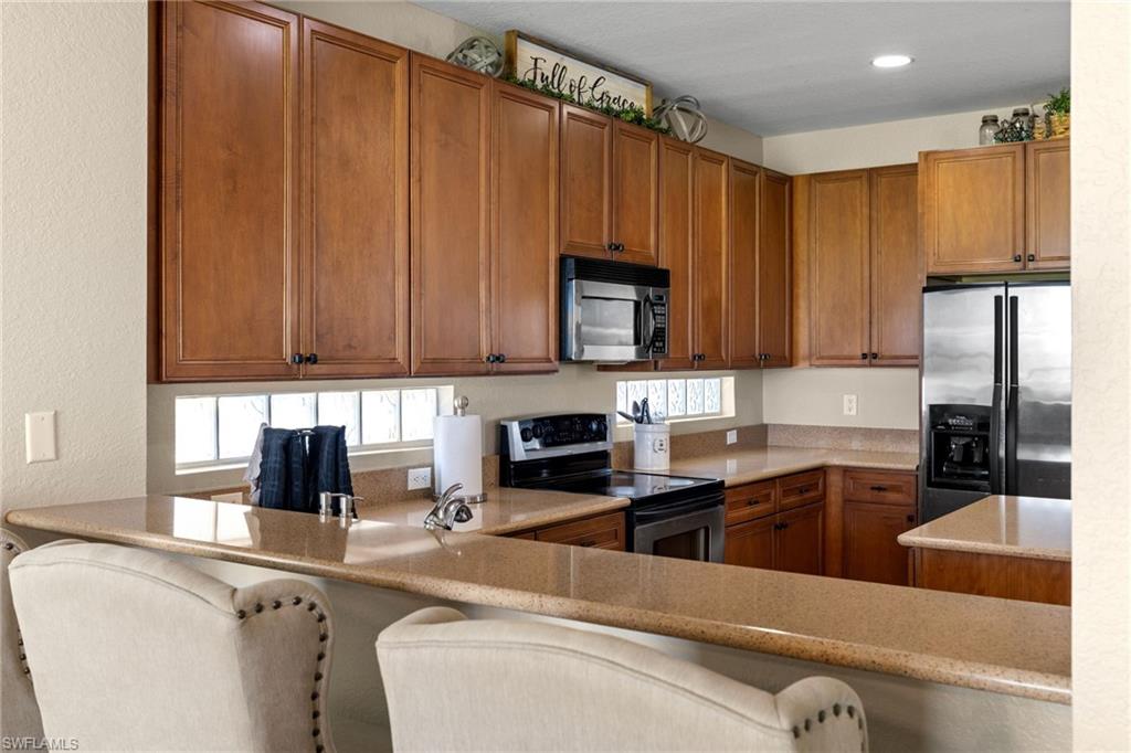 2104 Par Drive Naples, FL 34120 - Photo 13 of 37 a kitchen with stainless steel appliances granite countertop a refrigerator a stove top oven a sink and dishwasher