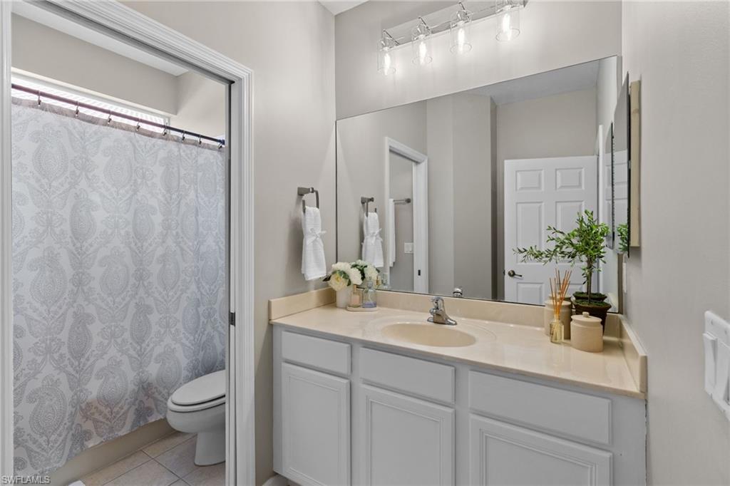 2104 Par Drive Naples, FL 34120 - Photo 26 of 37 a bathroom with a double vanity sink toilet and a mirror