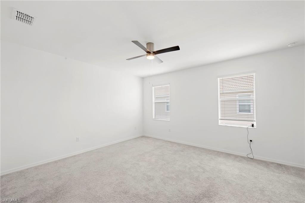 2827 Blossom Way Naples, FL 34120 - Photo 11 of 34 Carpeted empty room featuring baseboards and a ceiling fan