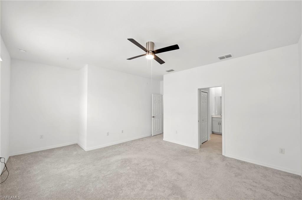 2827 Blossom Way Naples, FL 34120 - Photo 12 of 34 Unfurnished bedroom with light colored carpet and a ceiling fan