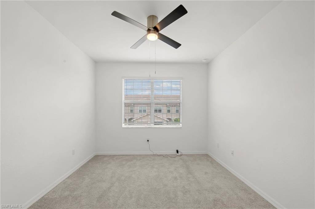 2827 Blossom Way Naples, FL 34120 - Photo 14 of 34 Empty room with ceiling fan and carpet floors