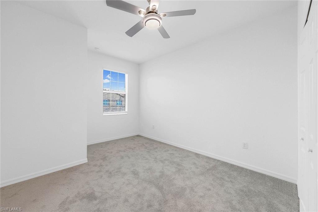 2827 Blossom Way Naples, FL 34120 - Photo 14 of 31 Empty room with light carpet and a ceiling fan