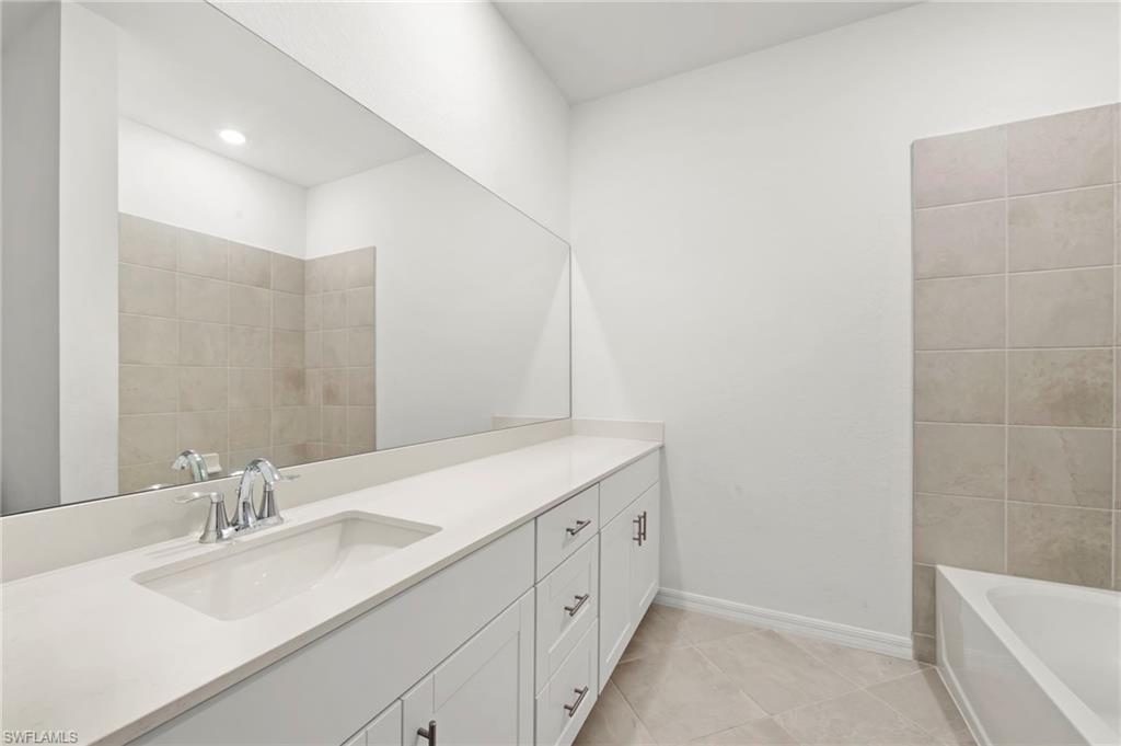 2827 Blossom Way Naples, FL 34120 - Photo 16 of 34 Bathroom featuring vanity, a bath, and light tile patterned floors