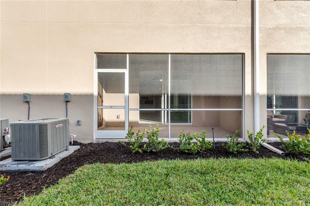 2827 Blossom Way Naples, FL 34120 - Photo 18 of 31 Exterior view of a cooling unit and stucco siding