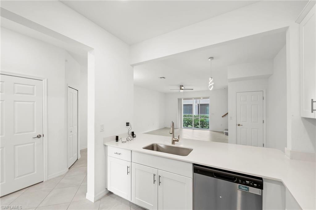 2827 Blossom Way Naples, FL 34120 - Photo 9 of 34 Kitchen featuring a peninsula, dishwasher, white cabinetry, a ceiling fan, and light tile patterned floors