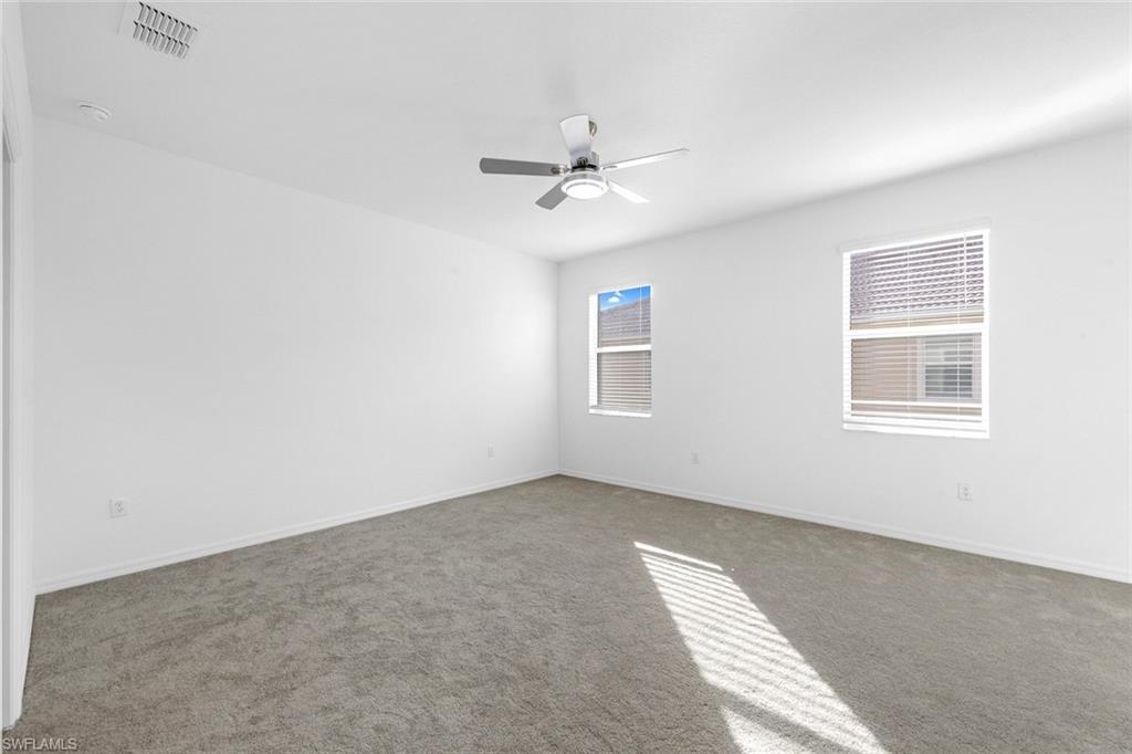 2827 Blossom Way Naples, FL 34120 - Photo 10 of 31 Spare room featuring carpet flooring and a ceiling fan