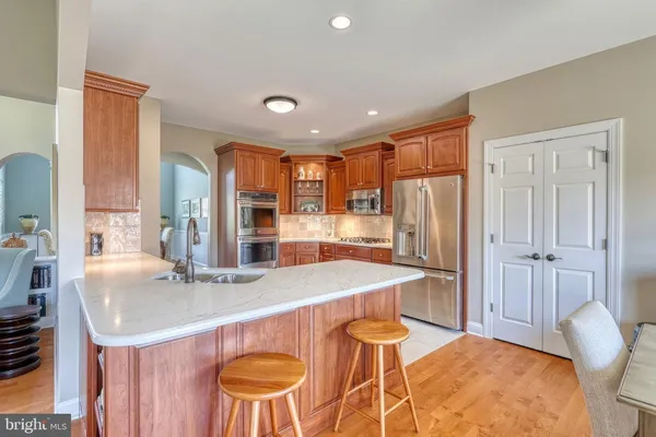 a kitchen with stainless steel appliances granite countertop a sink counter space and a stove top oven